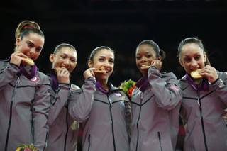 U.S. gymnasts McKayla Maroney, Kyla Ross, Alexandra Raisman, Gabrielle Douglas and Jordyn Wieber bite their gold medals at the Artistic Gymnastics women's team final at the 2012 Summer Olympics, July 31, 2012, in London. 