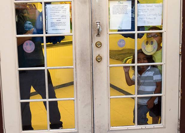 Children look out from Little Annie's Day Care at the Desert Gardens Condominiums complex near Martin Luther King Jr. Boulevard and Bonanza Road Monday, Aug. 6, 2012.