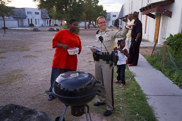 Metro Police Officer T. Brosnahan talks with resident Tiffani Ledet at the Desert Gardens Condominiums complex near Martin Luther King Jr. Boulevard and Bonanza Road Monday, Aug. 6, 2012.