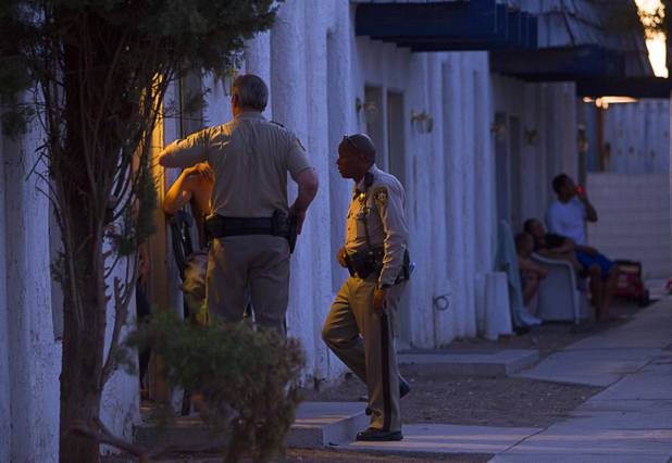 Metro Police officers check in with a resident at the Desert Gardens Condominiums complex near Martin Luther King Jr. Boulevard and Bonanza Road Monday, Aug. 6, 2012. In addition to fighting crime, officers check with residents to see if the property owners are maintaining the units.