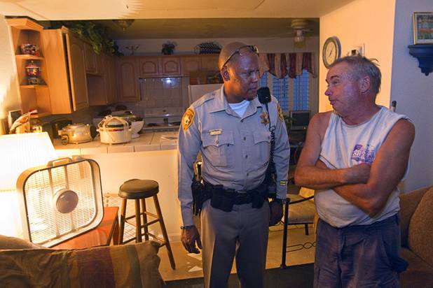 Metro Police Officer Jeff Willis talks with David Sweetland who had no working air conditioning in his unit at the Desert Gardens Condominiums complex near Martin Luther King Jr. Boulevard and Bonanza Road Monday, Aug. 6, 2012. In addition to fighting crime, officers check with residents to see if the property owners are maintaining the units.