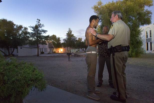 Metro Police Capt. Larry Burns talks with resident Drayton Barlow at the Desert Gardens Condominiums complex near Martin Luther King Jr. Boulevard and Bonanza Road Monday, Aug. 6, 2012. Barlow said he has no cold air in the upstairs of his unit and no cold water. He also has a newborn daughter and a 17-month-old son living in the apartment.