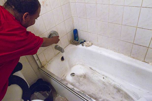 Resident Patrick Murphy demonstrates problems with the bathtub in his unit at the Desert Gardens Condominiums complex near Martin Luther King Jr. Boulevard and Bonanza Road Monday, Aug. 6, 2012. When the drain of a neighboring unit was cleaned, dirty water backed up into his tub and it drains very slowly, he said.