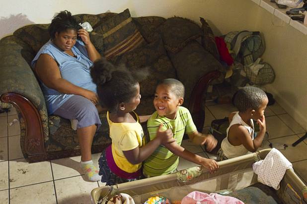 Patricia Murphy, 6, and Makye Thompson, 4, play in an apartment as LaToya Thompson watches from the couch at the Desert Gardens Condominiums complex near Martin Luther King Jr. Boulevard and Bonanza Road Monday, Aug. 6, 2012.
