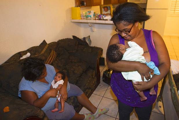 Sisters LaToya, left, and Porcha Thompson hold Porcha's 2-month-old twins Camyah, left, and Camari at the Desert Gardens Condominiums complex near Martin Luther King Jr. Boulevard and Bonanza Road Monday, Aug. 6, 2012.
