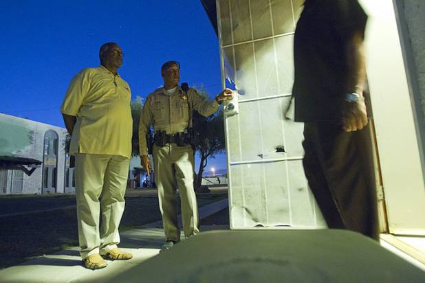 Pastor Willie Cherry, left, and Metro Police Officer Jeff Willis stand by a unit at the Desert Gardens Condominiums complex near Martin Luther King Jr. Boulevard and Bonanza Road Monday, Aug. 6, 2012.