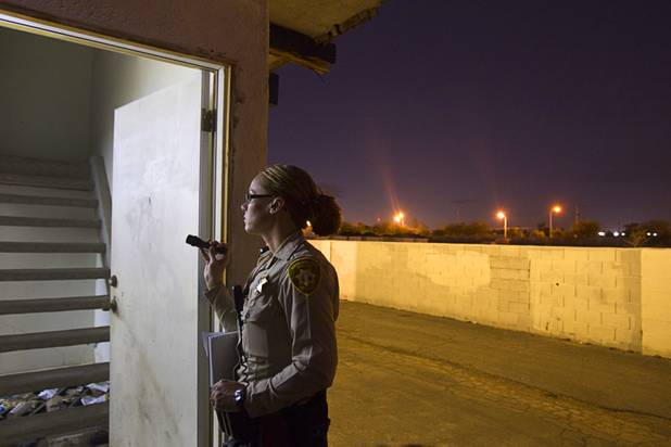 Metro Police Officer T. Brosnahan shines a flashlight into an open and vacant unit at the Desert Gardens Condominiums complex near Martin Luther King Jr. Boulevard and Bonanza Road Monday, Aug. 6, 2012. Of 147 units in the complex, only about 50 are occupied, said a Metro Police officer.