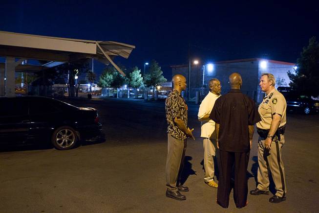 Community leaders and Metro Police Capt. Larry Burns gather in the parking lot of the Desert Gardens Condominiums complex near Martin Luther King Jr. Boulevard and Bonanza Road Monday, Aug. 6, 2012. From left are: Alonso Jones, Pastor Willie Cherry, and Charles Webb.