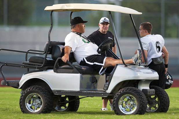 Palo Verde High School Head Coach Darwin Rost, center, talks with offensive line coach Ted Ortale during practice at the school Tuesday, Aug. 7, 2012. Rost's son Parker is at right. Palo Verde will face Desert Vista High School (Arizona) in the Sollenberger Classic at the University of Phoenix Stadium in Arizona on Aug. 18.