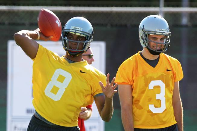 UNLV quarterback Caleb Herring throws while Nick Sherry looks on during practice Tuesday, August 7, 2012.