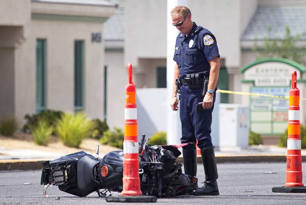 A Henderson Police officer looks over a motorcycle after an accident at Eastern Avenue and Wigwam Parkway Wednesday, Aug. 8, 2012. The driver of the motorcycle died in the accident. 