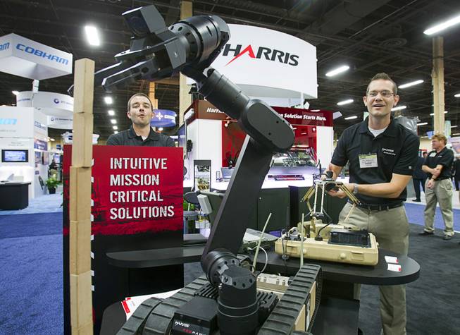 Paul Bosscher, right, of the Harris Corporation, reacts after stacking 10 jenga blocks - tieing the company record - using the Harris Redhawk robotic arm control system during the Association for Unmanned Vehicles Systems International (AUVSI) convention at the Mandalay Bay Thursday, Aug. 9, 2012. The wireless system gives operators tactile feedback for precision manipulation.
