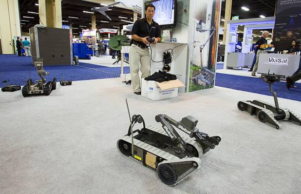 Jonathan Lesser, marketing and exhibit manager for iRobot, operates a 310 SUGV robot during the Association for Unmanned Vehicles Systems International (AUVSI) convention at the Mandalay Bay Thursday, Aug. 9, 2012. The portable robot can be used in areas that are inaccessible or too dangerous for people.