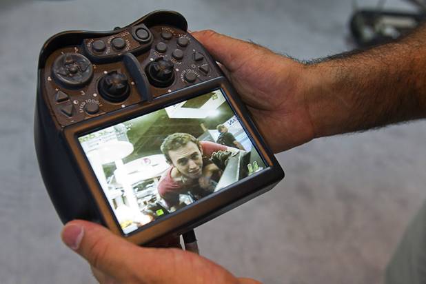 The image of attendee Harrison Gale is shown in the screen of an iRobot 310 SUGV controller as he inspects the robot during the Association for Unmanned Vehicles Systems International (AUVSI) convention at the Mandalay Bay Thursday, Aug. 9, 2012.