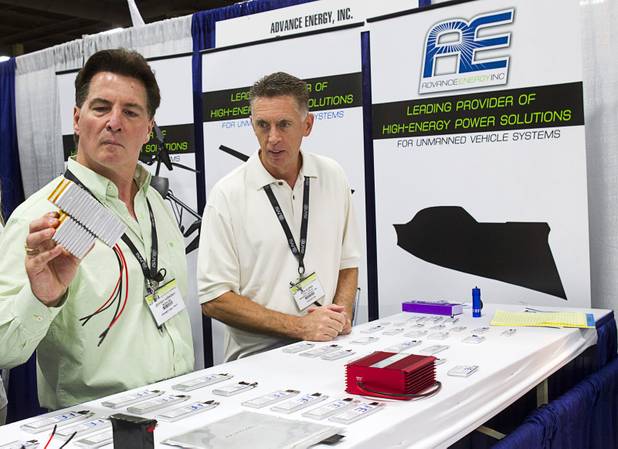 Bob Burns, right, general manager of Las Vegas-based Advance Energy, shows batteries to an attendee during the Association for Unmanned Vehicles Systems International (AUVSI) convention at the Mandalay Bay Thursday, Aug. 9, 2012.