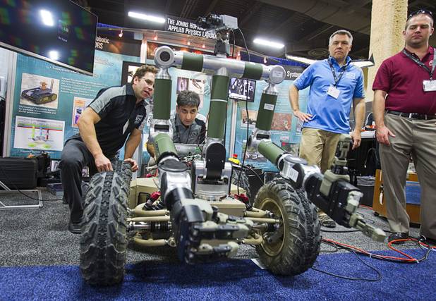 Engineers Matthew Johannes, left, and Kapil Katyal work on a drone with a Synbotics platform at the Johns Hopkins University Applied Physics Laboratory booth during the Association for Unmanned Vehicles Systems International (AUVSI) convention at the Mandalay Bay Thursday, Aug. 9, 2012.