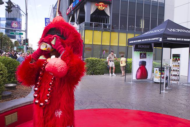 Actor Donn Harper, dressed as Elmo, cools down after buying some tea from a self-service Honest Tea kiosk on the Las Vegas Strip Monday, Aug. 13, 2012. Observers from the tea company watched from a distance and recorded how many people paid for the tea and how many did not. The Honest Cities social experiment is being held in 50 locations in 30 cities.