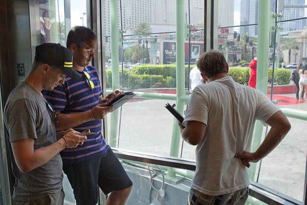 Honest Tea marketing managers keep an eye on a self-service Honest Tea kiosk on the Las Vegas Strip Monday, Aug. 13, 2012. Joe Stemmer, left, Josh Cunningham, center, and Ryan Vande Griendt watched from a distance and recorded how many people paid for the tea and how many did not. The Honest Cities social experiment is being held in 50 locations in 30 cities.