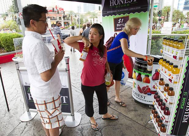 Canadian tourists Johnny and Joanne (no last name provided) pick out tea at a self-service Honest Tea kiosk on the Las Vegas Strip Monday, Aug. 13, 2012. Observers from the tea company watched from a distance and recorded how many people paid for the tea and how many did not. The Honest Cities social experiment is being held in 50 locations in 30 cities.