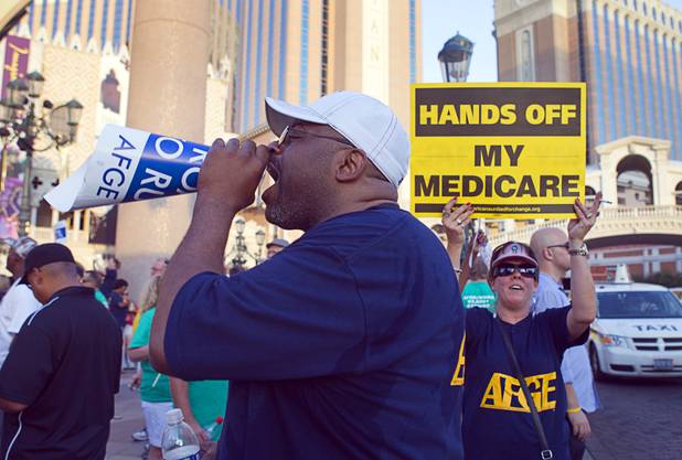 American Federation of Government Employees (AFGE) union members Mark Barnes, left, and Barbara Anderson picket against Republican vice presidential candidate Paul Ryan in front of the Venetian on the Las Vegas Strip Tuesday, Aug. 14, 2012. Ryan was reportedly meeting privately with a small group of supporters at the casino owned by Sheldon Adelson, a billionaire and major donor to Republican campaigns.