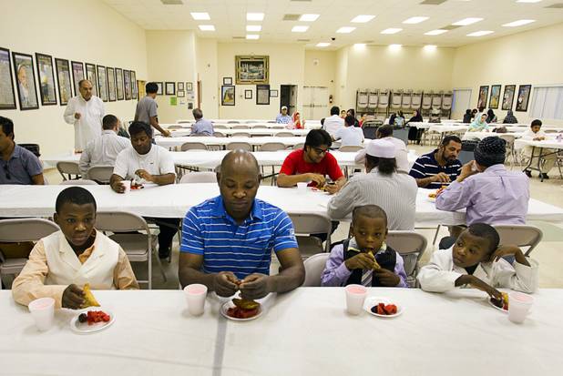 Yussef Mberwa, center breaks the day's fast with his brothers Abukar Mukoma, left, 13, Mohammed Mukoma, 7, and Apdi Mukoma, 5, on the 27th day of Ramadan at the Jamia Masjid mosque Wednesday, Aug. 15, 2012. During the month of Ramadan, Muslims fast from dawn until sunset.