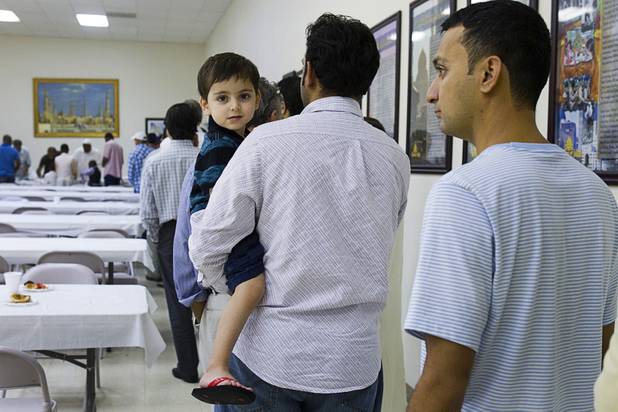 Nadar Khan holds his son Azan, 3, as they line up for dinner after prayers on the 27th day of Ramadan at the Jamia Masjid mosque Wednesday, Aug. 15, 2012. During the month of Ramadan, Muslims fast from dawn until sunset.