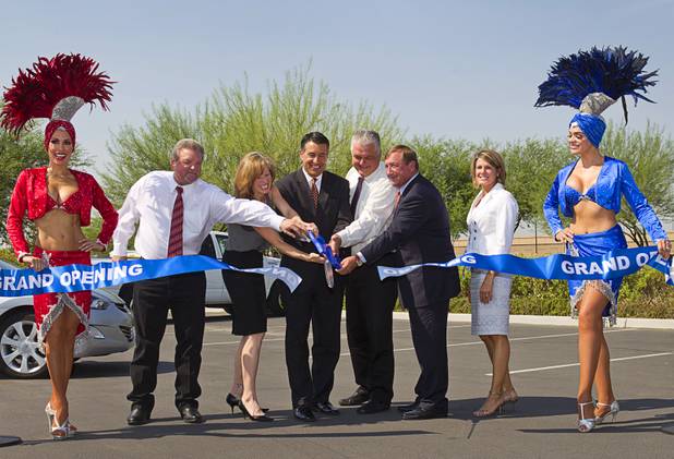 Showgirls Jennifer Johnson, left and Porsha Revesz flank officials as they cut a ceremonial ribbon during the "grand opening" of the I-15 South Design-Build Project in the Town Square parking lot Wednesday, Aug. 15, 2012. From left are: Corey Newcome of Las Vegas Paving, Susan Martinovich, director of the Nevada Department of Transportation, Nevada Governor Brian Sandoval, Clark County Commissioner Steve Sisolak, Rossi Ralenkotter, president/CEO of the Las Convention and Visitors Authority, and Tina Quigley, general manager of the Regional Transportation Commission. Construction on  $246 million improvement project started in Spring 2010.