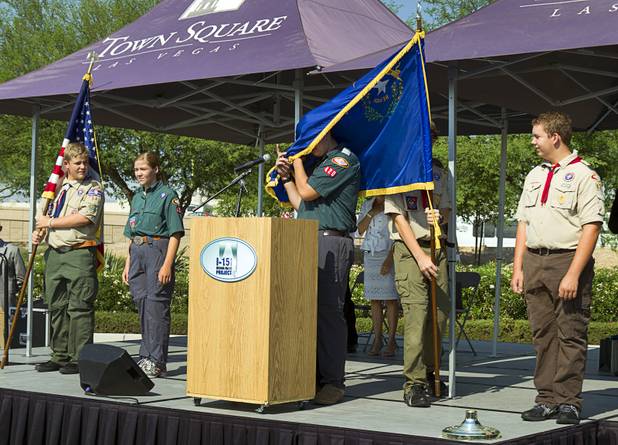 Mark Ono, center, gets caught up in the Nevada flag as members of the boy scouts and venturing crew Troop 420 present the colors during a ceremony to celebrate the "grand opening" of the I-15 South Design-Build Project in the Town Square parking lot Wednesday, Aug. 15, 2012. Construction on  $246 million improvement project started in Spring 2010.