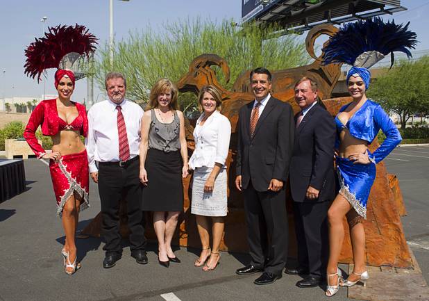 Showgirls Jennifer Johnson, left and Porsha Revesz flank officials as they pose for a photo during the "grand opening" of the I-15 South Design-Build Project in the Town Square parking lot Wednesday, Aug. 15, 2012. From left are: Corey Newcome of Las Vegas Paving, Susan Martinovich, director of the Nevada Department of Transportation, Tina Quigley, general manager of the Regional Transportation Commission, Nevada Governor Brian Sandoval, Rossi Ralenkotter, president/CEO of the Las Convention and Visitors Authority. Construction on  $246 million improvement project started in Spring 2010.