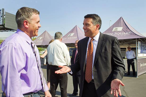 Nevada Governor Brian Sandoval, right, talks with KLAS-TV traffic reporter Ken Smith before a ceremony to celebrate the "grand opening" of the I-15 South Design-Build Project in the Town Square parking lot Wednesday, Aug. 15, 2012. Construction on  $246 million improvement project started in Spring 2010.
