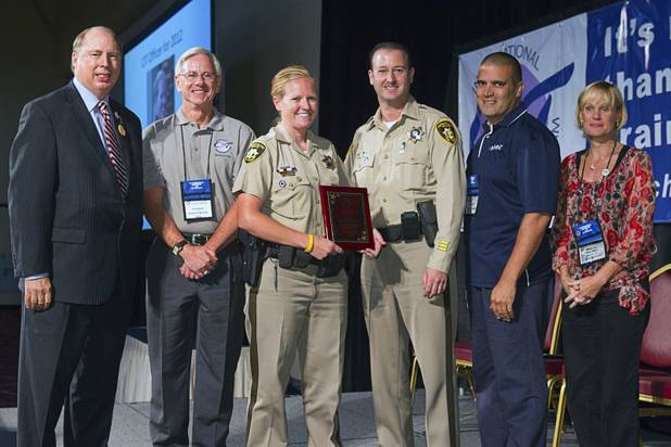 Metro Police Officer Booke Lavin, center left, poses with her award for Crisis Intervention Team (CIT) Officer of the Year during a CIT International awards luncheon at the South Point Tuesday, Aug. 21, 2012.  Lavin was honored with the award after calming a suicidal man and then following up to make sure the man received a variety of social services. With  Lavin from left: Sam Cochran, co-chairman of the CIT board, CIT president Michael Woody, Metro Officer Jeremy Levy, 2006 CIT Officer of the Year, Sgt. Andy Suvada, of Streetsboro, Ohio, 2011 CIT Officer of the Year, and Michele Saunders, CIT International vice president.