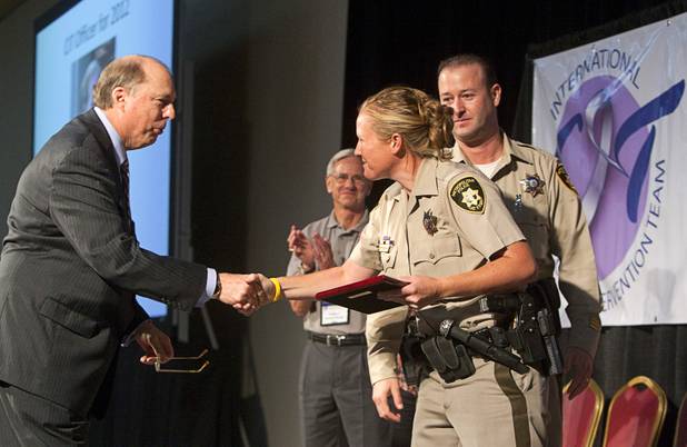 Sam Cochran, left, co-chairman of the CIT board of directors, congratulates Metro Police Officer Booke Lavin, after  Lavin was named as Crisis Intervention Team (CIT) Officer of the Year during a CIT International awards luncheon at the South Point Tuesday, Aug. 21, 2012.  Lavin was honored with the award after calming a suicidal man and then following up to make sure the man received a variety of social services.