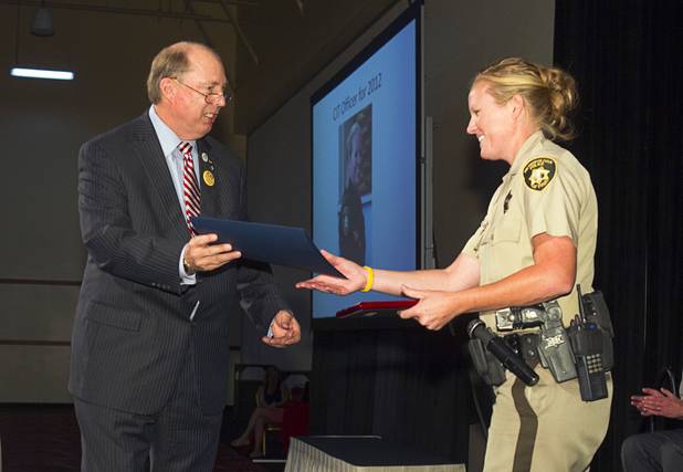 Metro Police Officer Booke Lavin receives the award for Crisis Intervention Team (CIT) Officer of the Year and a certificate from Senate Majority Leader Harry Reid's office during a CIT International awards luncheon at the South Point Tuesday, Aug. 21, 2012.  Lavin was honored with the award after calming a suicidal man and then following up to make sure the man received a variety of social services.
