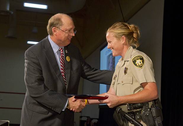 Sam Cochran, left, co-chairman of the CIT board of directors, congratulates Metro Police Officer Booke Lavin, after  Lavin was named as Crisis Intervention Team (CIT) Officer of the Year during a CIT International awards luncheon at the South Point Tuesday, Aug. 21, 2012.  Lavin was honored with the award after calming a suicidal man and then following up to make sure the man received a variety of social services.
