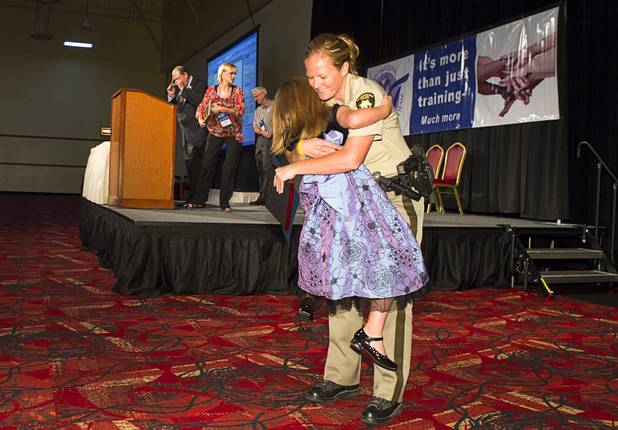 Metro Police Officer Booke Lavin gets a hug from her daughter Justice, 6, after being named Crisis Intervention Team (CIT) Officer of the Year during a CIT International awards luncheon at the South Point Tuesday, Aug. 21, 2012.  Lavin was honored with the award after calming a suicidal man and then following up to make sure the man received a variety of social services.