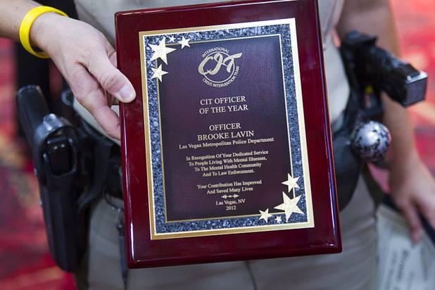 Metro Police Officer Booke Lavin displays her award for Crisis Intervention Team (CIT) Officer of the Year during a CIT International awards luncheon at the South Point Tuesday, Aug. 21, 2012.  Lavin was honored with the award after calming a suicidal man and then following up to make sure the man received a variety of social services.