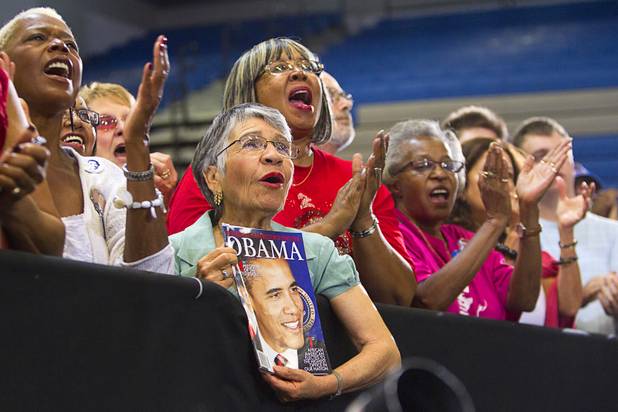 Maria Gray, center, holds a magazine with a photo of President Barack Obama during the president's rally at Canyon Springs High School in North Las Vegas Wednesday, Aug. 22, 2012.