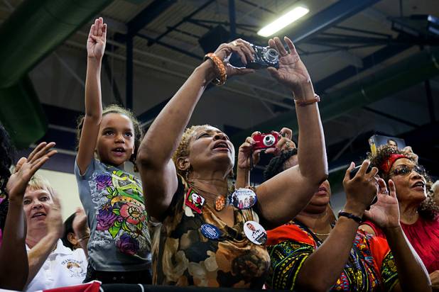 A woman takes a photo of President Barack Obama as he speaks during a rally at Canyon Springs High School in North Las Vegas Wednesday, Aug. 22, 2012.