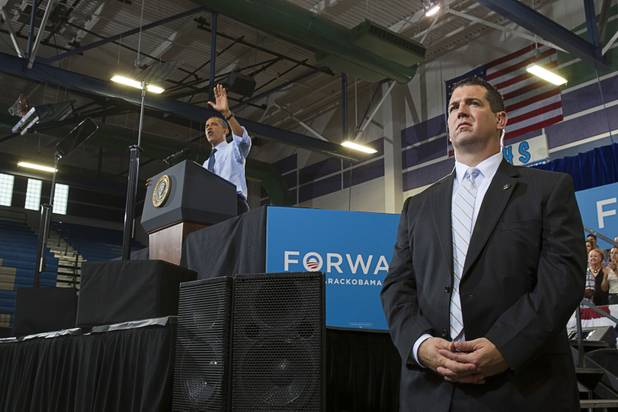 A Secret Service agent keeps an eye on the crowd as President Barack Obama speaks during a rally at Canyon Springs High School in North Las Vegas Wednesday, Aug. 22, 2012.