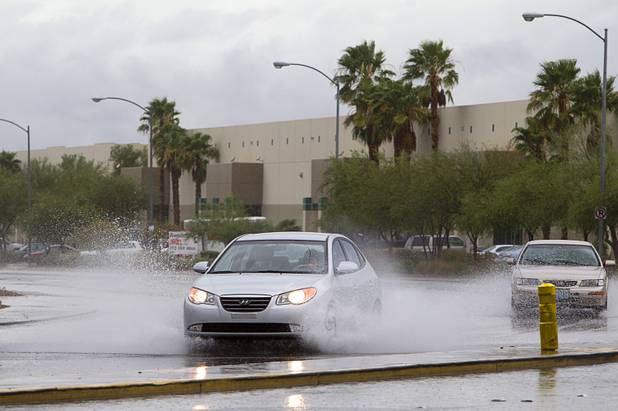 A car drives through storm runoff on North Pecos Road in North Las Vegas on Wednesday, Aug. 22, 2012.