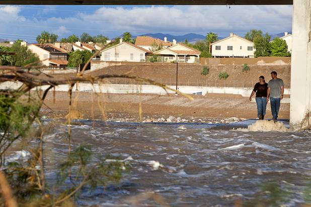 Nikki and Chris Burry walk under a bridge at Arroyo Grande Boulevard as they view storm run-off in the Pittman wash in Henderson on Wednesday, Aug. 22, 2012. 