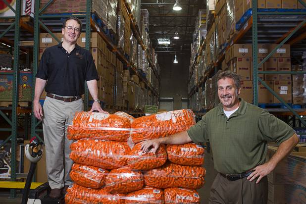 Brian Burton, left, president/CEO, and John Livingston, chief operating officer, pose in a warehouse at the Three Square Food Bank Wednesday, Aug. 22, 2012.