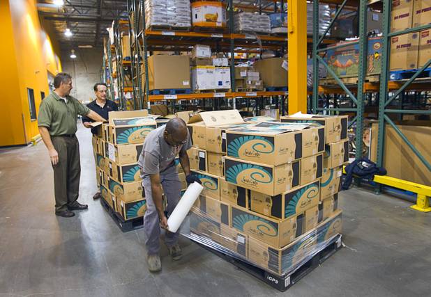 Warehouse assistant Joe Thomas wraps a load of produce to go into a cooler after inspecting it at the Three Square Food Bank Wednesday, Aug. 22, 2012.