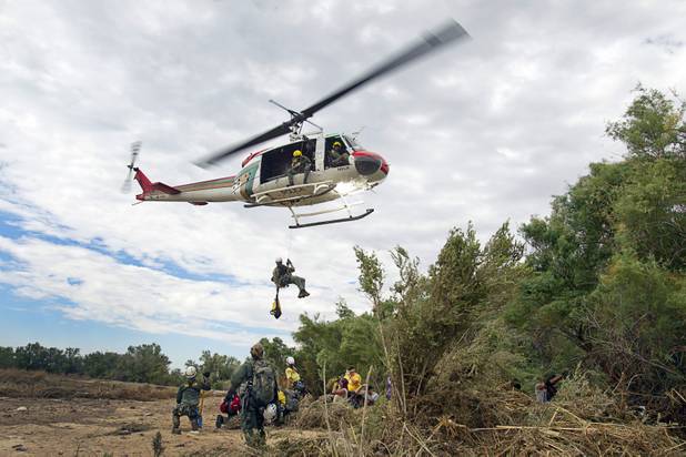 A Metro Search and Rescue helicopter drops off Search and Rescue Officer John Thayer during a search for Henderson teen William Mootz near the Duck Creek channel, north of Sam Boyd Stadium, Thursday, Aug. 23, 2012. Mootz, a Green Valley High School student, was swept away by storm run-off in the Pittman Wash Wednesday.