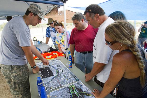 Mark Omo, 16, left, looks over a map of the area during a search for Henderson teen William Mootz near the Duck Creek channel, north of Sam Boyd Stadium Thursday, Aug. 23, 2012. Mootz, a Green Valley High School student, was swept away by storm run off in the Pittman Wash Wednesday. Omo said he is in the same Boy Scout Troop as Mootz.