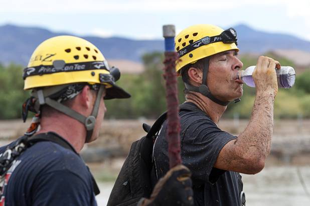 Henderson Fire Department engineer Scott Dakus, right, takes a break during a search for Henderson teen William Mootz near the Duck Creek channel, north of Sam Boyd Stadium Thursday, Aug. 23, 2012. Mootz, a Green Valley High School student was swept away by storm run off in the Pittman Wash Wednesday.