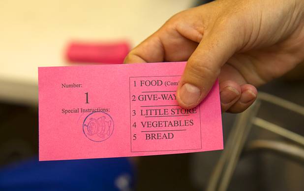 A woman shows her food ticket at Sunrise Baptist Church, 1780 Betty Lane, Thursday, Aug. 23, 2012. The stamp at left indicates that she has children at home.