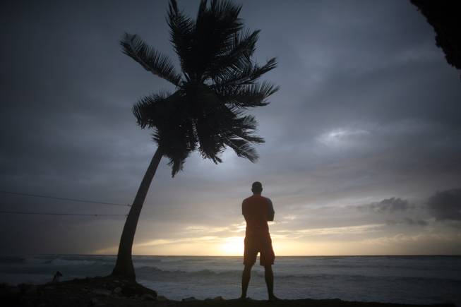 A man looks out at the beach as Tropical Storm Isaac approaches in Barahona, Dominican Republic, Friday, Aug. 24, 2012. Fears over the storm have forced the GOP to cancel Monday evening's events at the Republican National Convention in Tampa, Fla.
