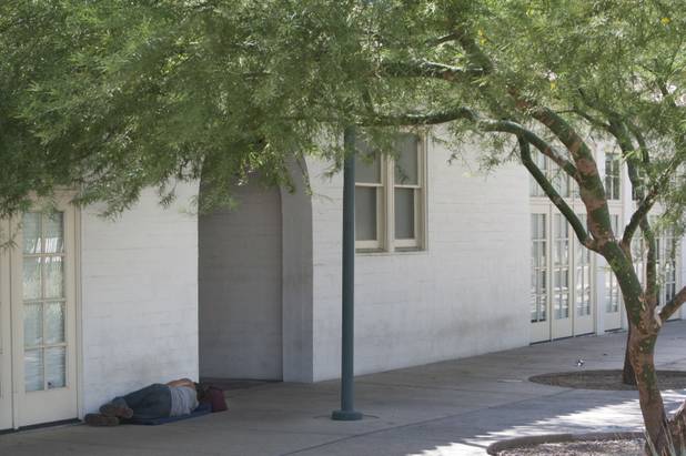 A man sleeps by the Historic Fifth Street School along the the Lewis Avenue Pedestrian Corridor Sunday, Aug. 26, 2012. STEVE MARCUS