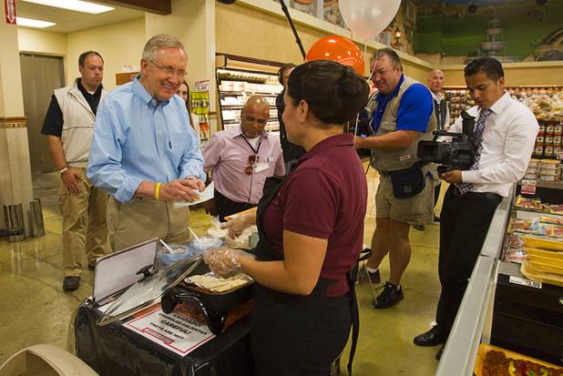 Senate Majority Leader Harry Reid tries a pork soft taco while touring the Cardenas  Market at Meadows Lane and Decatur Boulevard Monday, Aug. 27, 2012.